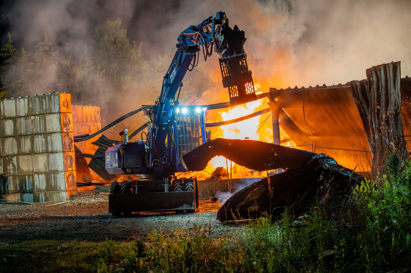 Bagger der Fachgruppe Räumen räumt nachts brennende Trümmer bei einem Großbrand