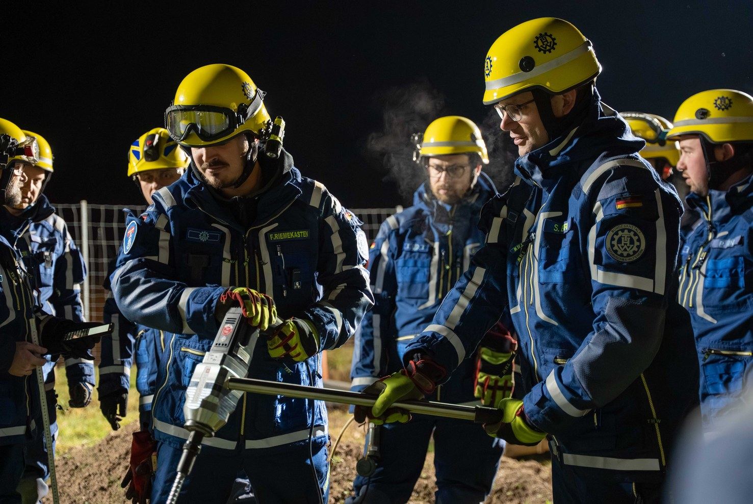 Gruppe von THW-Helferinnen und -Helfern mit Helmen bei einer Ausbildung